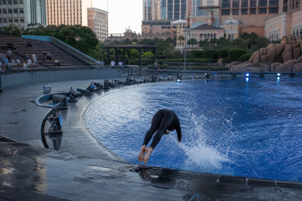 Flooded stage of an aquatic theatre with performers mid-dive