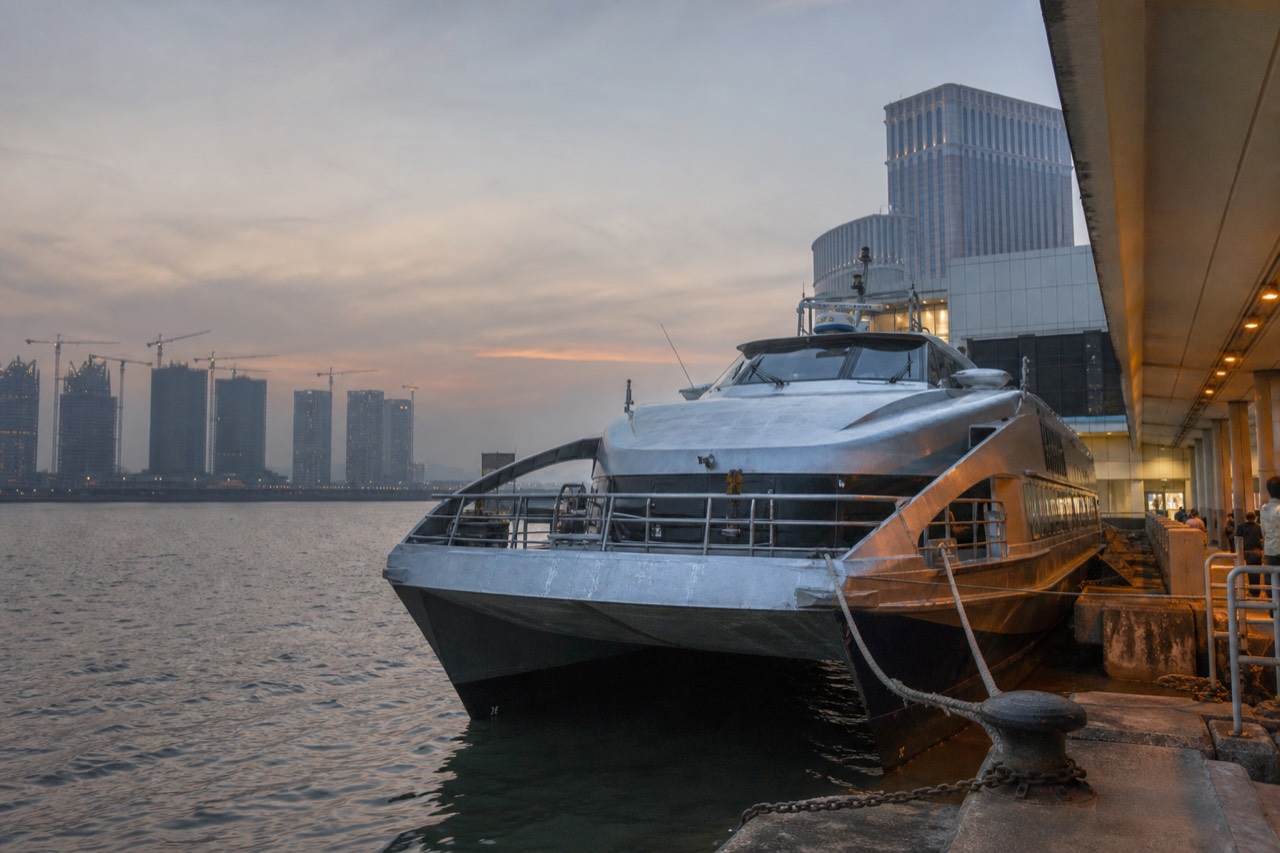 A high-speed catamaran at a ferry terminal berth at dusk