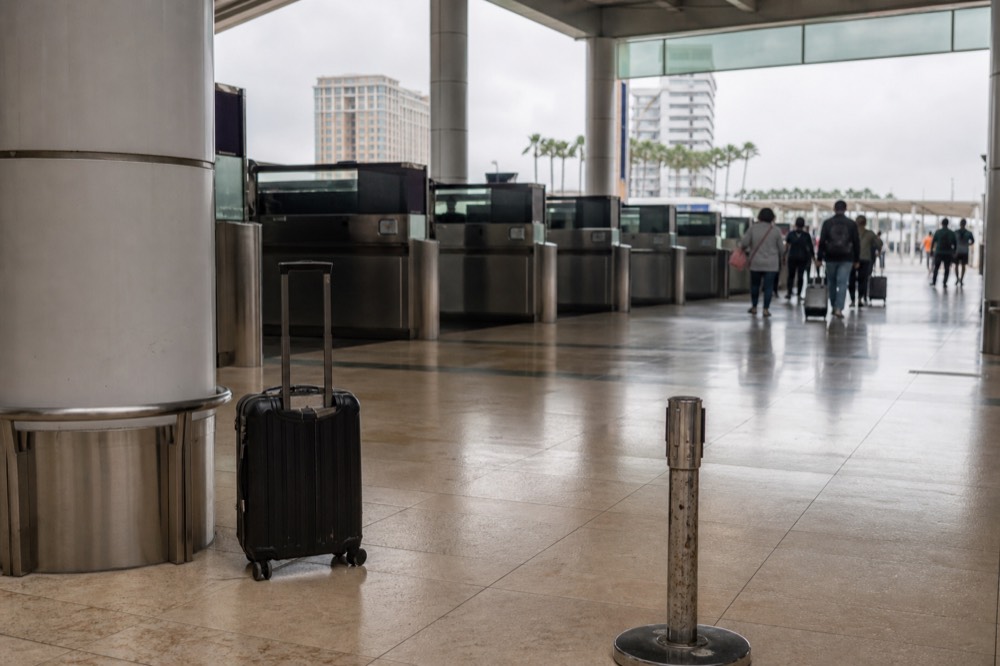 A ferry terminal concourse with departure boards above rows of gates