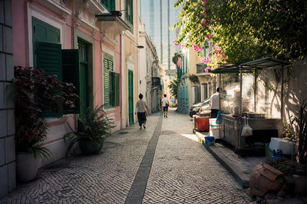 Historic Macau street with pastel colonial facades in afternoon light