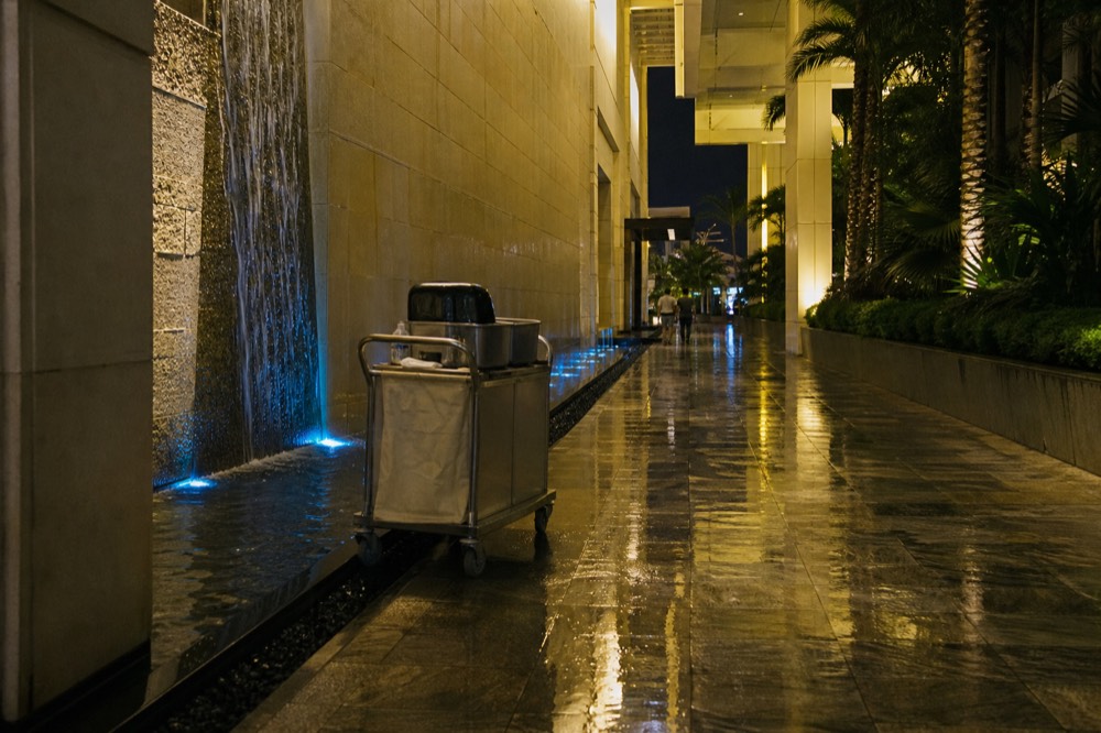 Bright modern resort corridor with water features at night