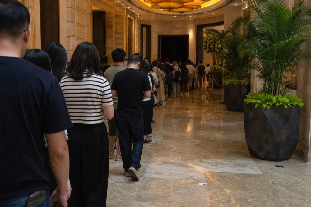A theatre foyer filling with arriving audience members before a performance