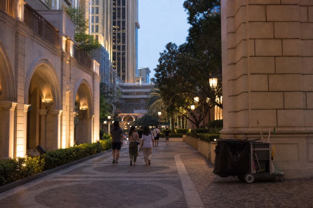 An evening promenade between illuminated Cotai resort buildings