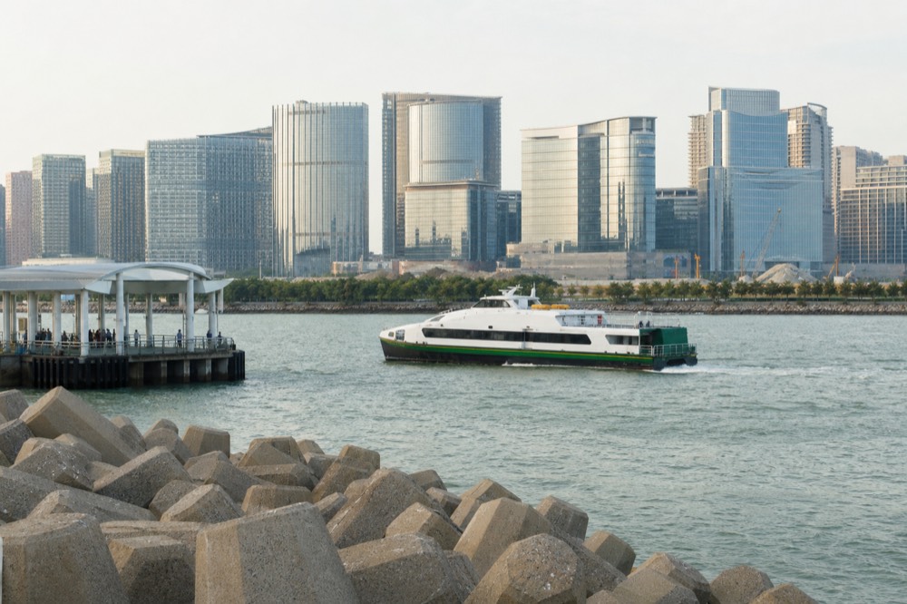 A ferry approaching a Macau terminal with resort towers beyond