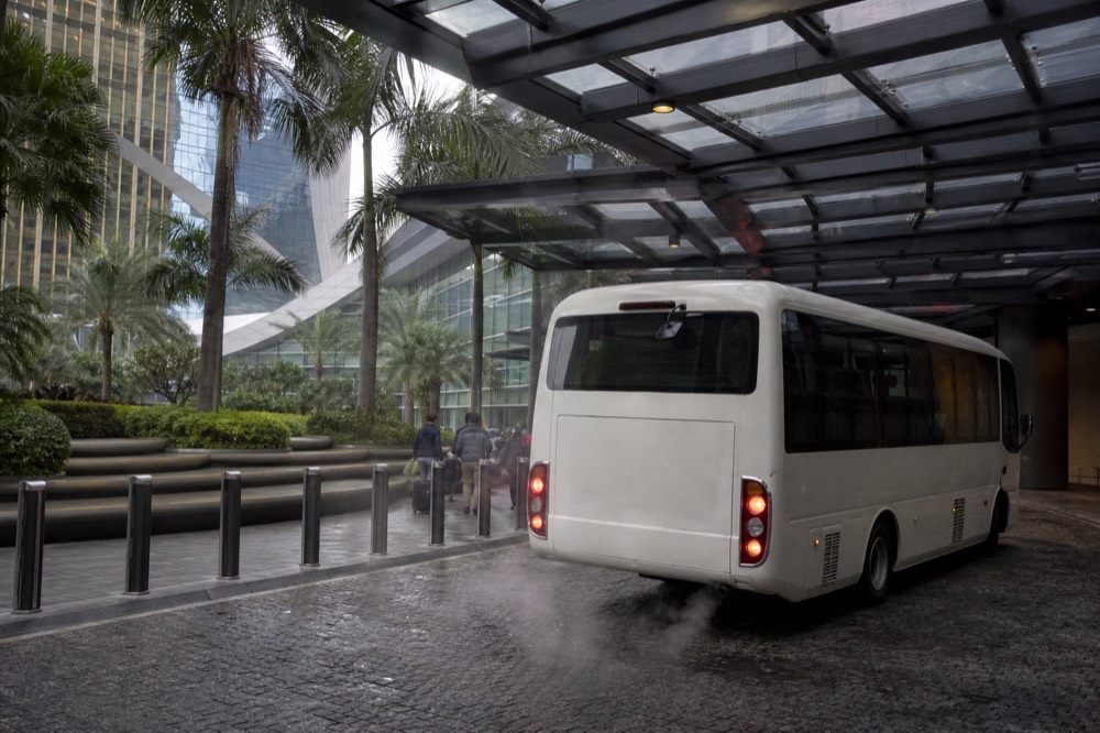 A resort shuttle bus parked at a covered pick-up point