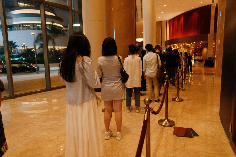 A theatre lobby with a ticket queue before an evening performance