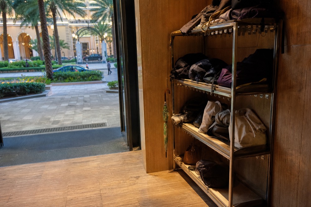 Cloakroom shelving with folded coats and stored bags beside a theatre entrance