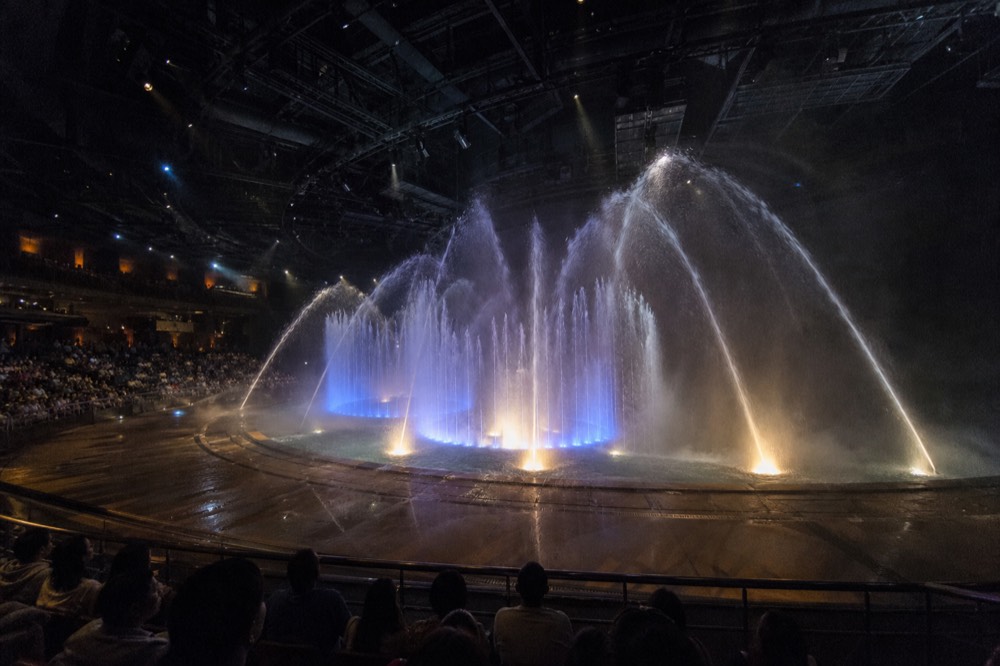Water jets erupting over the central stage during a House of Dancing Water performance