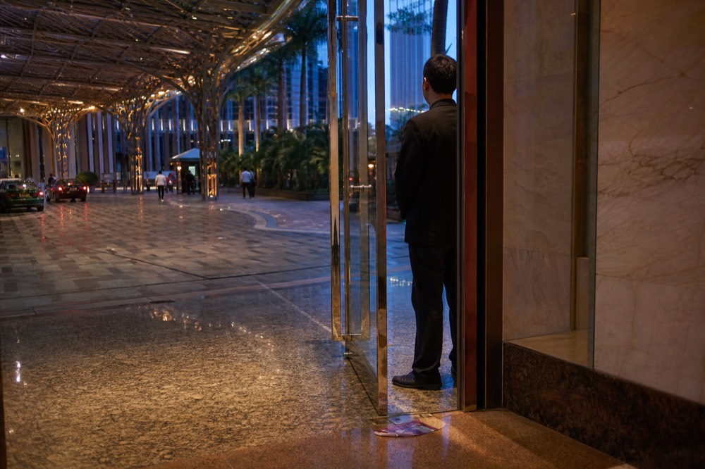 An usher standing at a theatre entrance as the house opens
