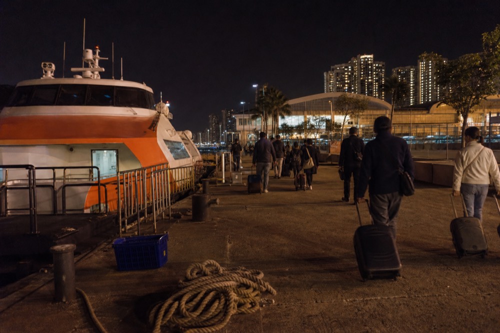 A ferry terminal at night with a Hong Kong to Macau vessel at its berth