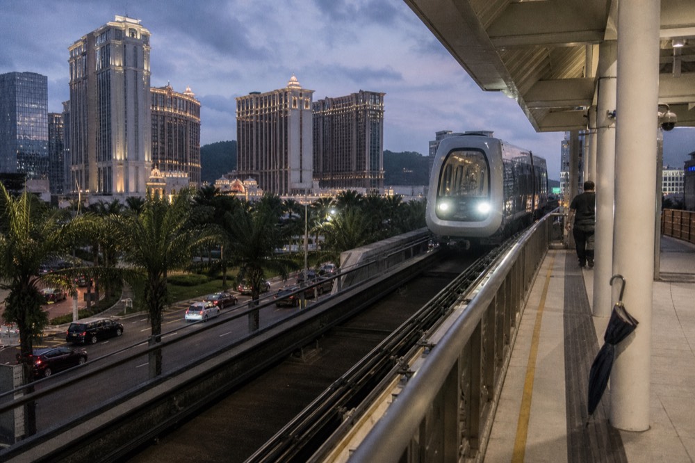 A light rail train arriving at a Macau station in the evening