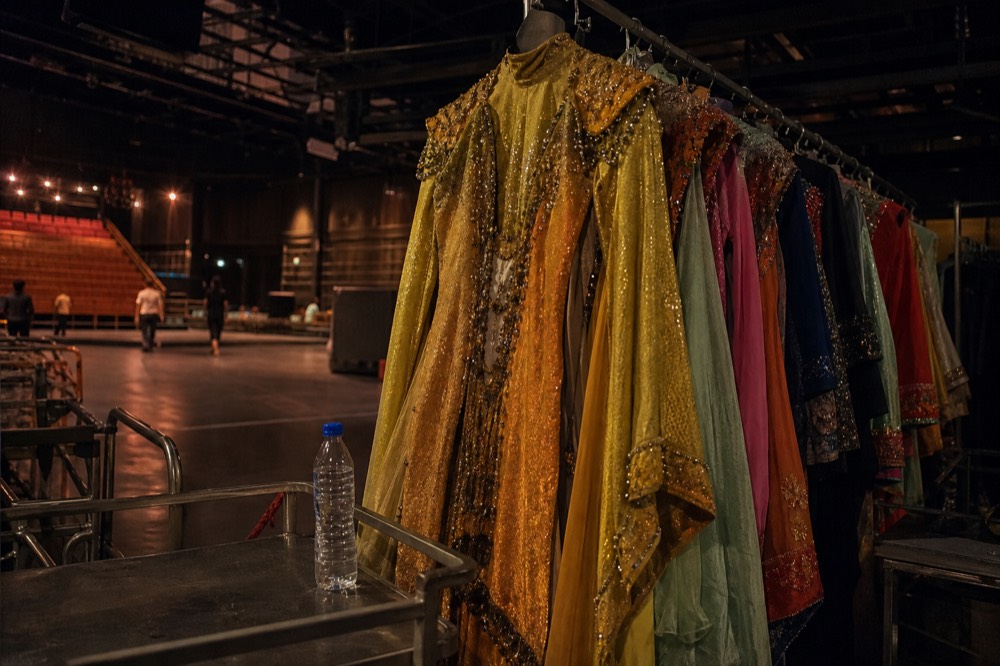 Elaborate stage costumes with rich colours displayed under theatre lighting