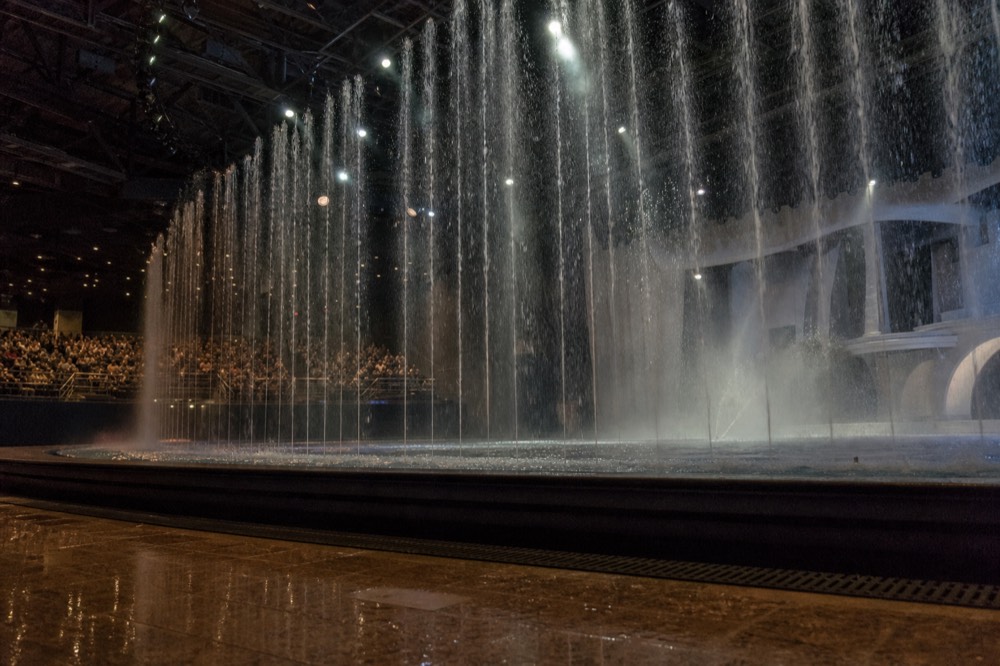 The Dancing Water Theatre pool mid-show with fountains rising toward the lights