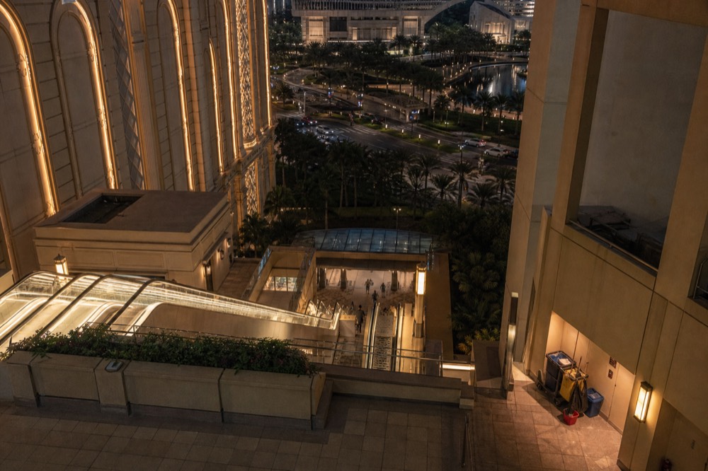 Resort walkways and escalators lit for the evening between the theatre and street level