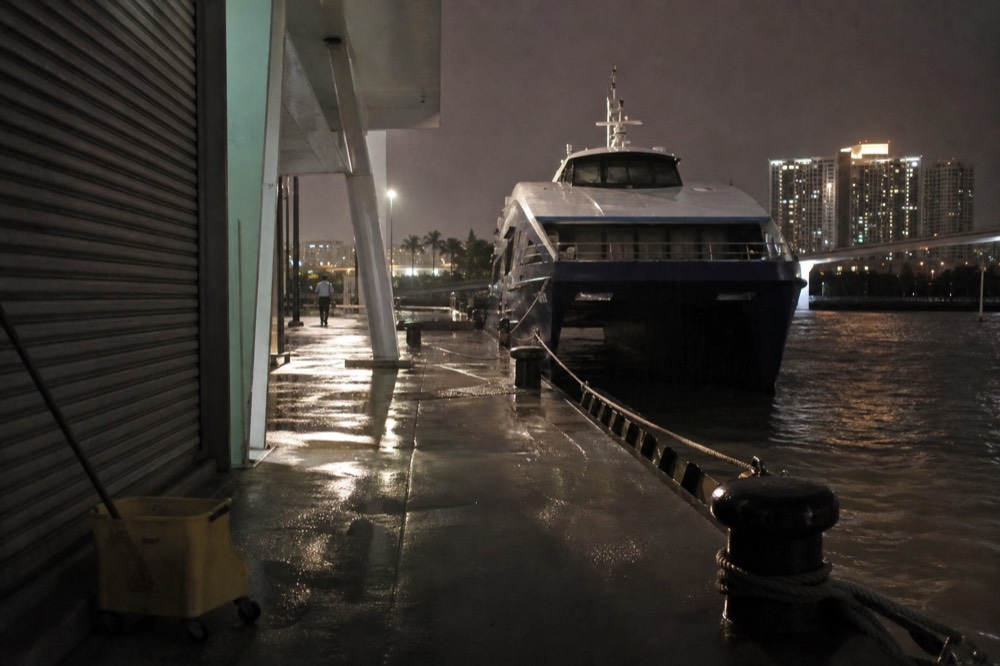 A ferry terminal at night with a vessel moored at the pier