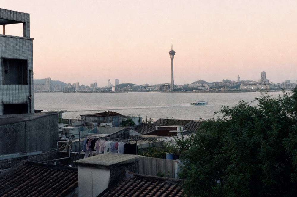 Macau Peninsula skyline and historic rooftops seen across the water at dusk