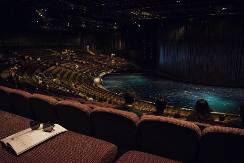 Curved rows of theatre seating rising around a vast stage pool
