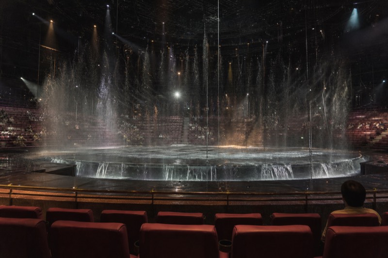 Water cascading across the stage of the Dancing Water Theatre under theatrical lighting