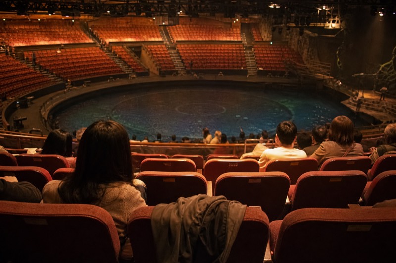 Audience members settling into their seats in the Dancing Water Theatre before the show begins